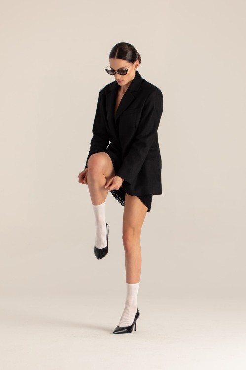 Czarna marynarka oversize – zbliżenie na fason, modelka w pochyleniu