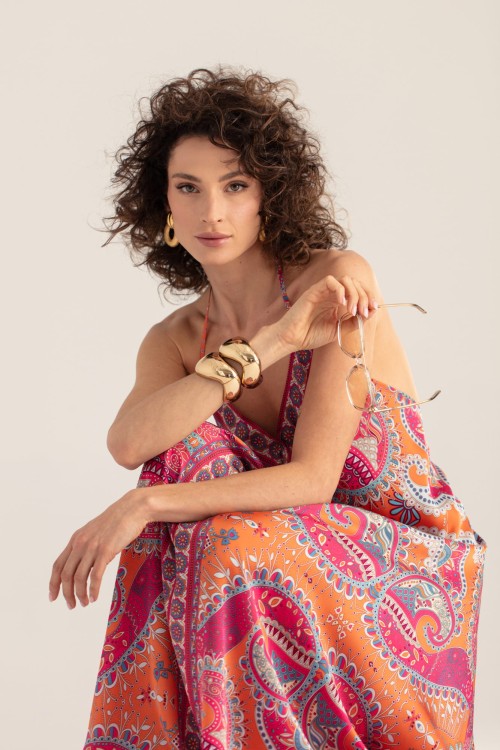 Zbliżenie – sukienka boho paisley, modelka siedzi i trzyma okulary