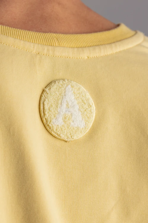 Bluza Blan żółta – modelka tyłem – widok pleców i luźnego fasonu – ANA atelier